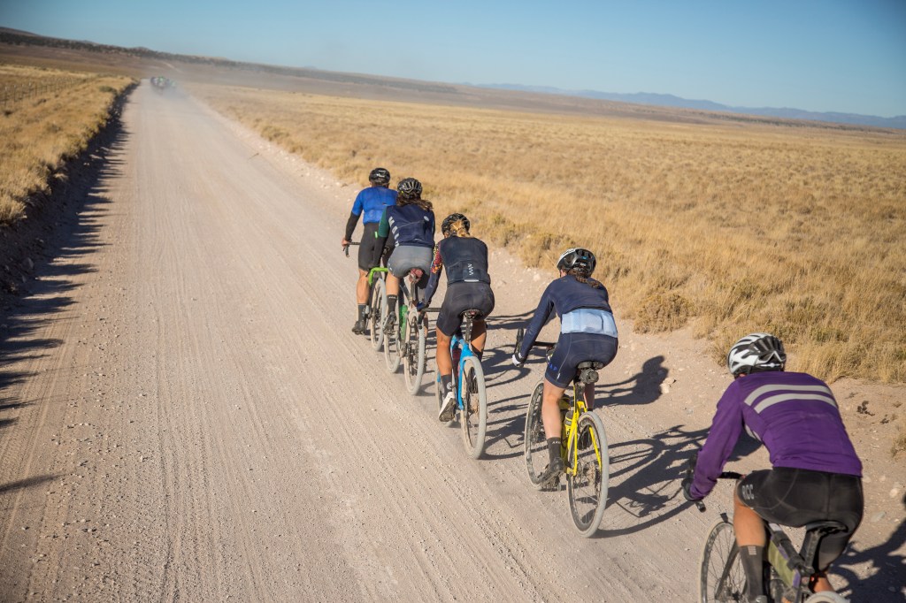 A person riding a bike down a dirt road

Description automatically generated